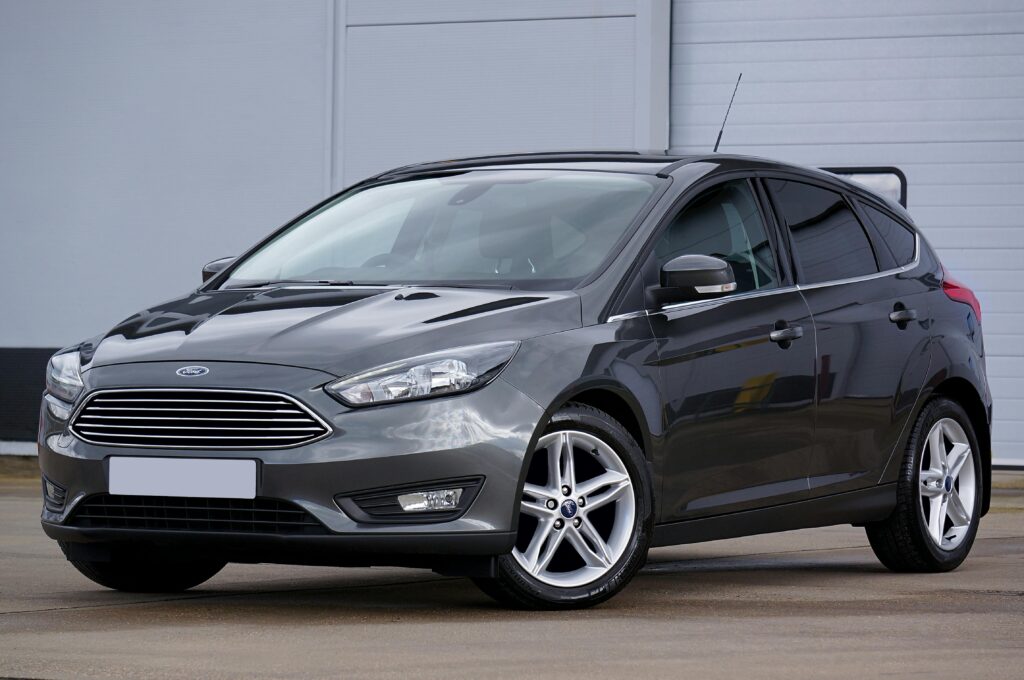 A sleek grey hatchback car parked outdoors, showcasing its modern design and shiny finish.